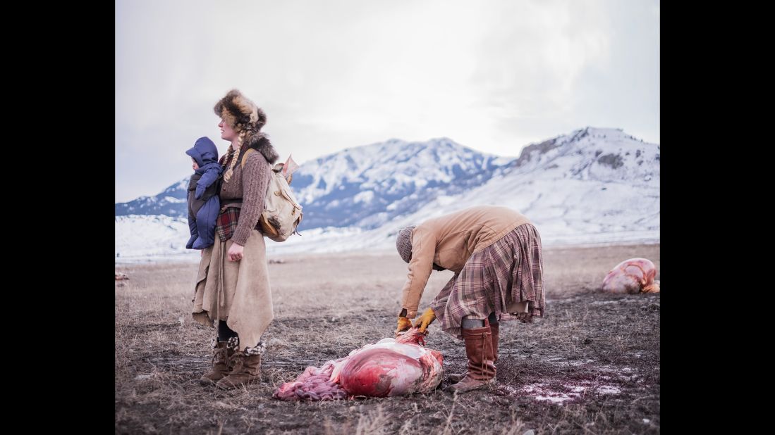 Ania pulls buffalo fat from a gut pile as Epona waits with her backpack. In the dead of winter, Matt Hamon went to rural Montana to photograph the lives of a group of people he calls "the gleaners."