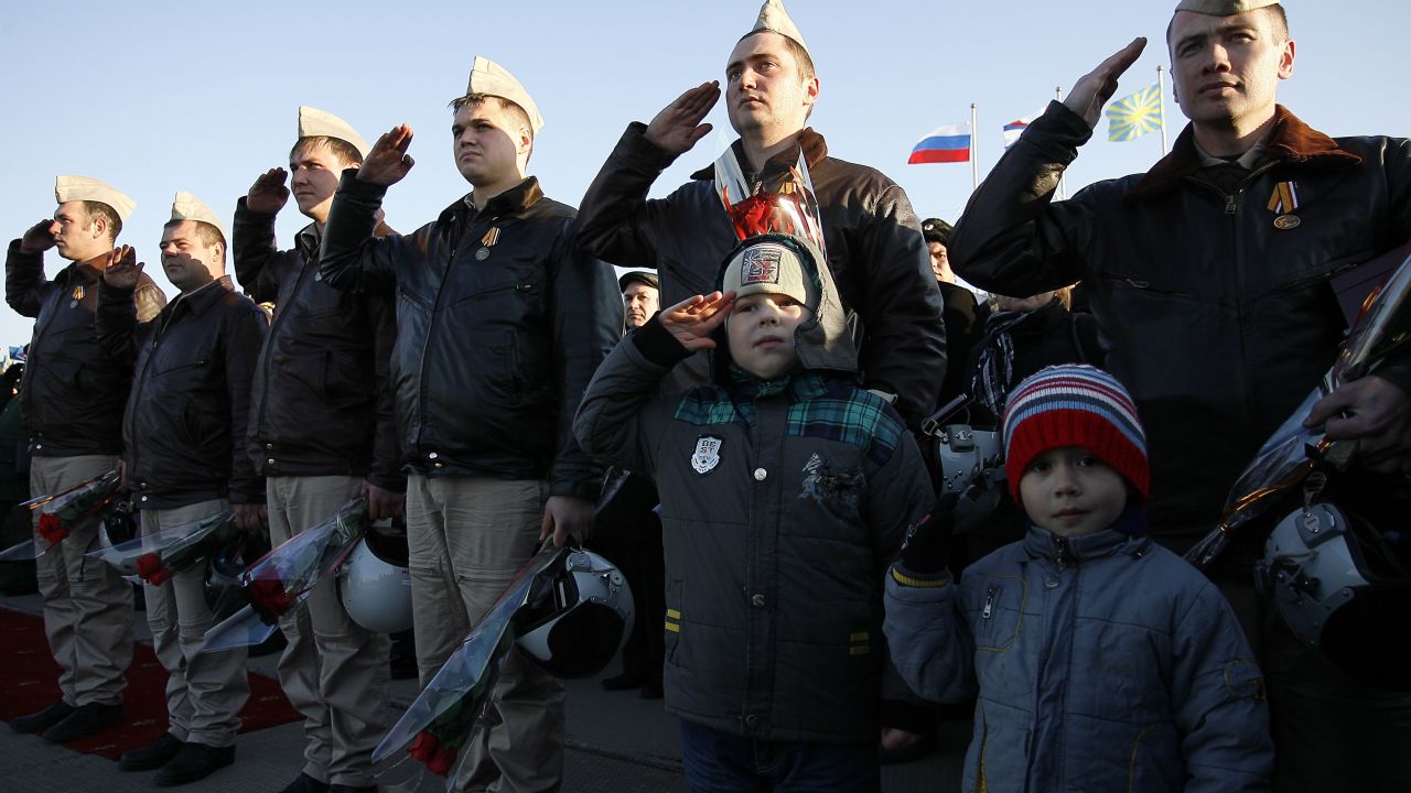 Russian air force pilots salute upon their arrival from Syria at an air base in the southern Russia's Krasnodar region Wednesday.