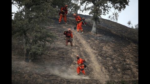 Firefighters hike down a hill in Clearlake, California, as they mop up hot spots from the Rocky Fire in August.