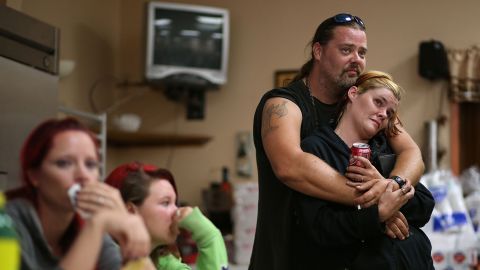 Evacuee James Logan embraces his wife, Lisa, as they listen to an update about a wildfire in Clearlake Oakes, California, in August. Drought conditions have fueled numerous wildfires across the state.
