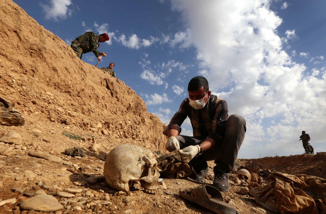 An Iraqi man inspects a mass grave near Sinjar in February 2015. 