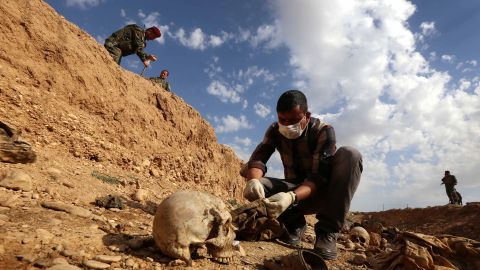 An Iraqi man inspects on February 3, 2015, the remains of members of the Yazidi minority killed by the Islamic State (IS) jihadist group after Kurdish forces discovered a mass grave near the village of Sinuni, in the northwestern Sinjar area.