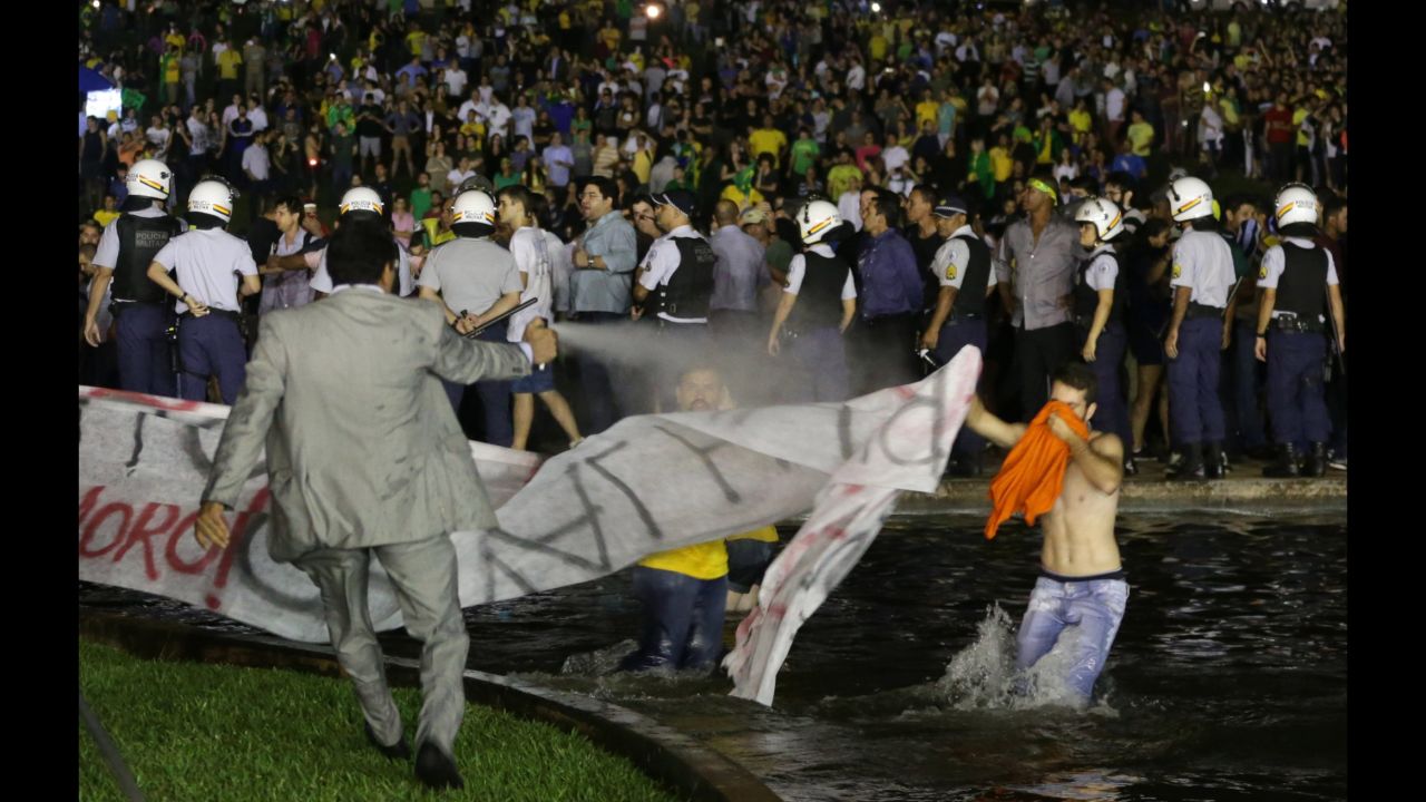 A police officer uses pepper spray on protesters to keep them from getting closer to the Congress building in Brasilia on March 16. 