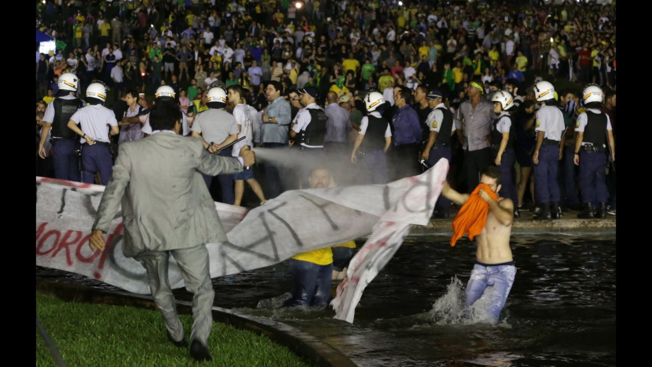 A police officer uses pepper spray on protesters to keep them from getting closer to the Congress building in Brasilia on March 16.