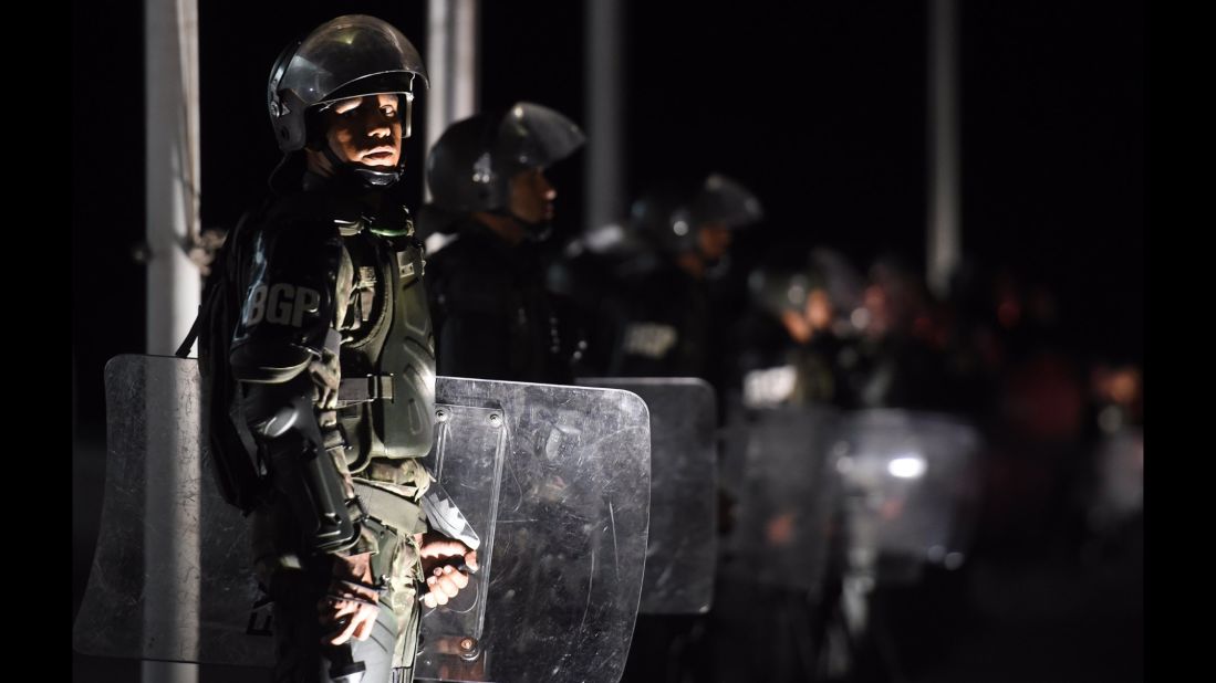 Riot police stand guard outside the presidential palace in Brasilia on March 16.