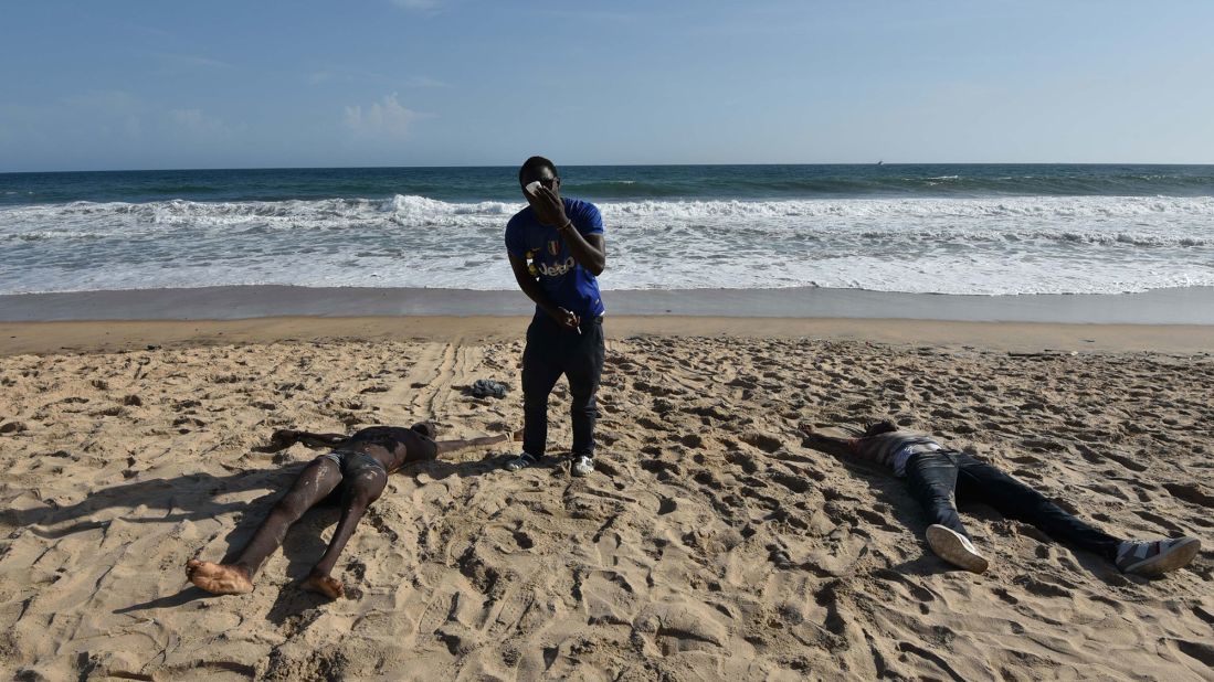 A man stands between bodies on a beach after the terror attack.  