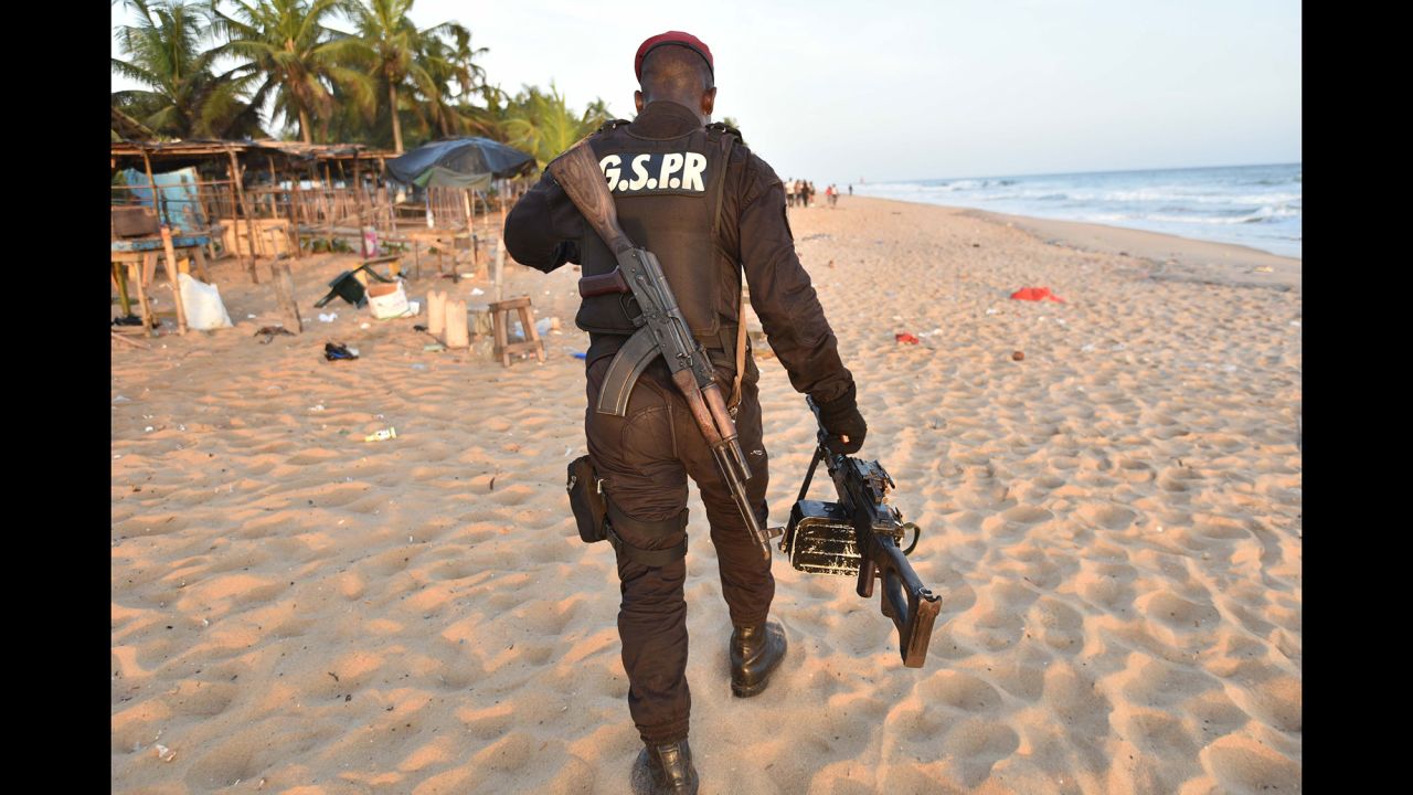 An Ivorian soldier carries a machine gun as he walks on the beach. Three terrorists also were killed, the Ivory Coast presidency said on its Facebook page, citing Interior Minister Hamed Bakayoko.