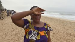 A woman cries at the beach as she looks for her son on March 14.