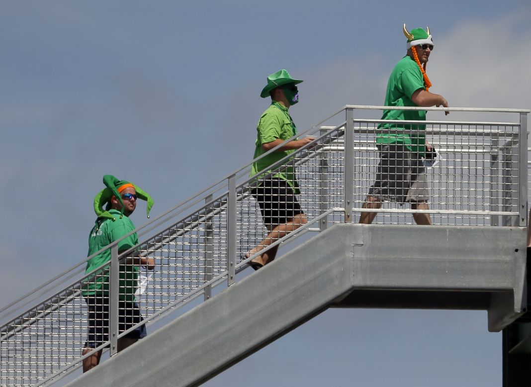 Three fans dressed in green walk up the stairwell to the roof of the Green Monster during the first inning of a spring training baseball game between the Baltimore Orioles and Boston Red Sox in Fort Myers, Florida.