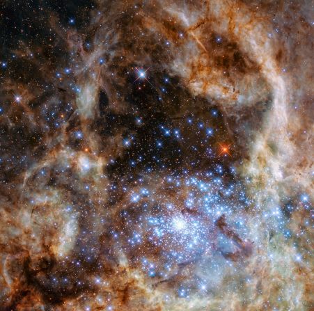 This image shows the central region of the Tarantula Nebula in the Large Magellanic Cloud. The young and dense star cluster R136, which contains hundreds of massive stars, is visible in the lower right of the image taken by the Hubble Space Telescope.