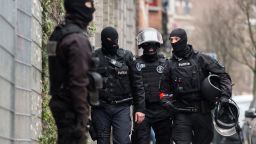 Police officers stand guard during a raid in the Molenbeek neighborhood of Brussels, Belgium, Friday March 18, 2016. Police have descended in force to search a residence in the Molenbeek, and Belgian media reported gunshots had been fired. RTBF French-language TV reported late Friday afternoon that two people had been wounded, and that one might be Paris attacks fugitive Salah Abdeslam. (AP Photo/Geert Vanden Wijngaert)