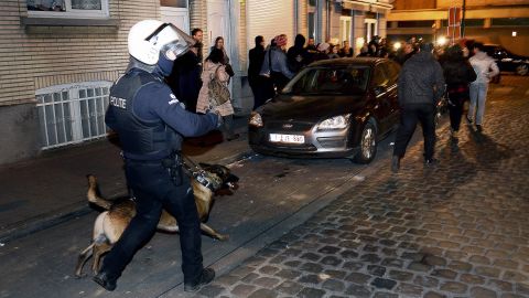 A policeman and a police dog face a crowd during a police operation in the Molenbeek-Saint-Jean district in Brussels, on March 18, 2016, as part of the investigation into the Paris November attacks.
The main suspect in the jihadist attacks on Paris in November, Salah Abdeslam, was arrested in a raid in Brussels on March 18, French police sources said. / AFP PHOTO / BELGA / DIRK WAEM / Belgium OUTDIRK WAEM/AFP/Getty Images