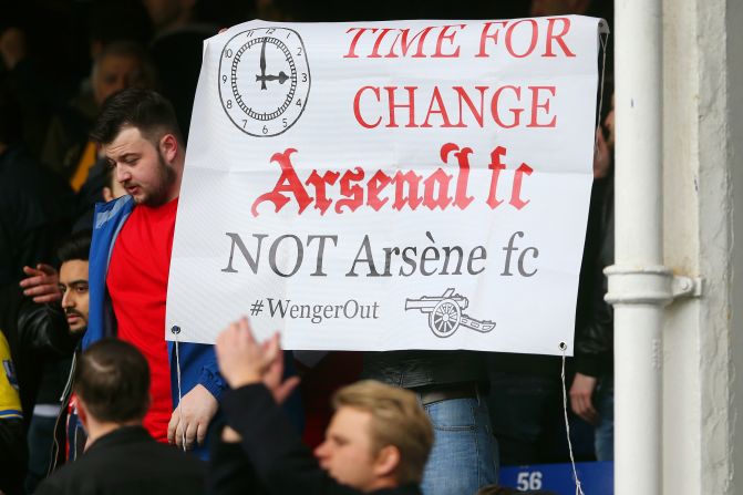 Despite Arsenal's 2-0 win, a disgruntled  Arsenal supporter holds a banner asking to replace manager Arsene Wenger after the Premier League match at Goodison Park on March 19, 2016 in Liverpool, England.