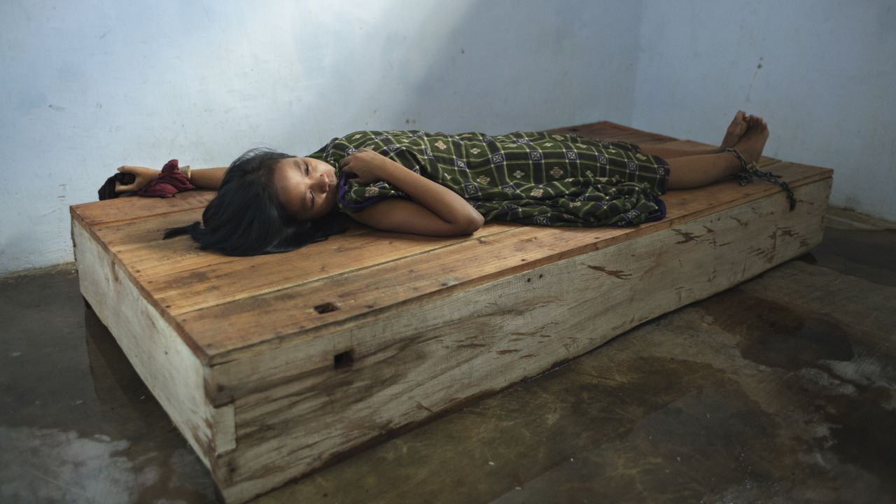 A 24-year-old female resident lies with her wrist and ankle chained to a platform bed at Bina Lestari healing center in Brebes, Central Java. After her husband abandoned her and her 5 year-old daughter, she began to suffer from depression, <a href="https://www.hrw.org/node/287537/" target="_blank" target="_blank">HRW said in the report.</a>