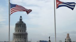 United States and Cuban flags fly side-by-side on the roof of the Iberostar Hotel Parque Central near El Capitolio (background) in the historic Old Havana neighborhood March 20, 2016 in Havana, Cuba. 