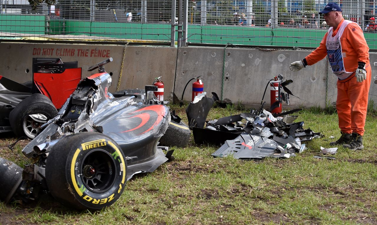 A track marshall examines debris following the crash. Alonso recalled: "You are just flying and then you see the sky, the ground, the sky, the ground."