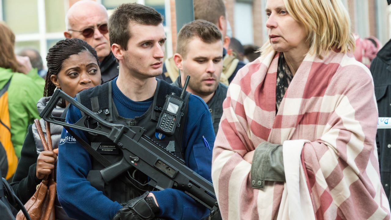 A police officer stands guard as people are evacuated from Brussels airport, after explosions rocked the facility Tuesday morning. 