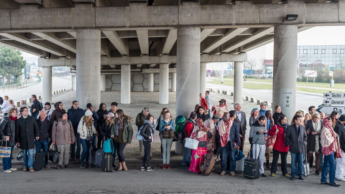 Passengers gather outside the airport.