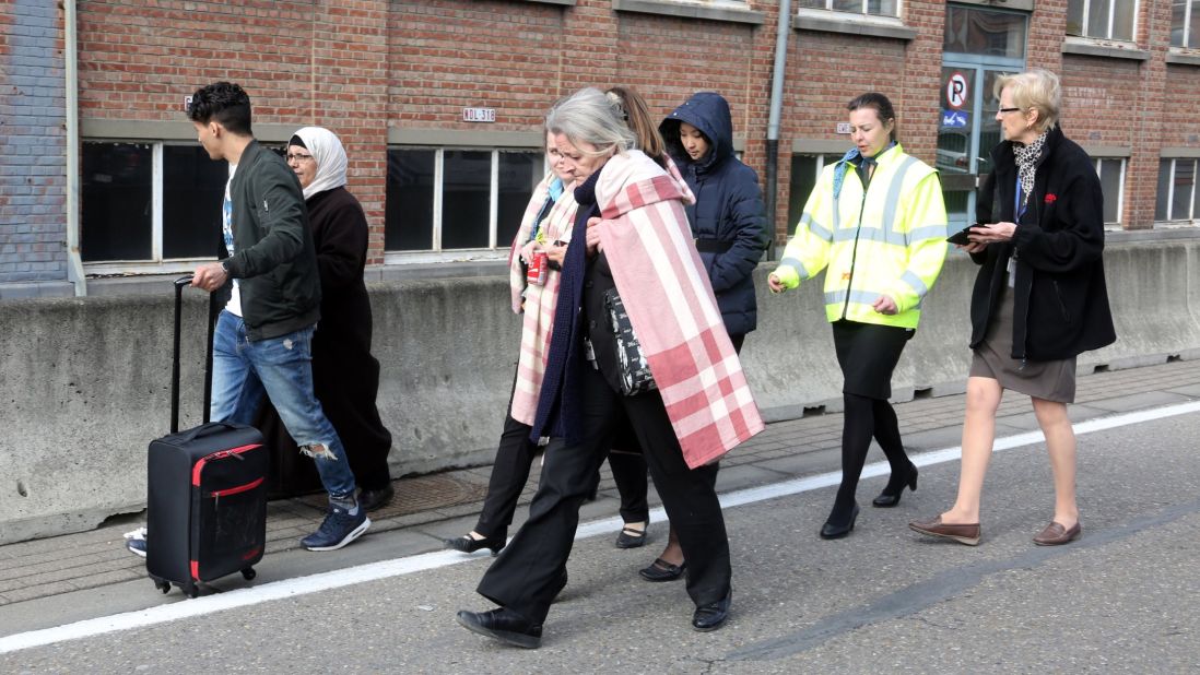 People are led away from the airport after the attacks.