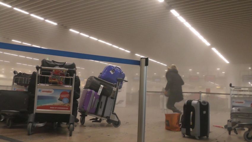 An unidentified traveler runs through the smoke filled terminal at Brussels Airport after explosion rocked the terminal Tuesday morning.