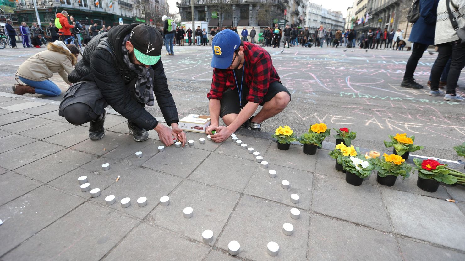 People leave candles and flowers in tribute to victims of triple bomb attacks in front of the stock exchange building in the city center of Brussels on Tuesday. 