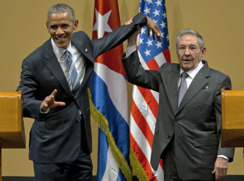 Castro tries to lift up Obama's arm at the end of a joint news conference on March 21.
