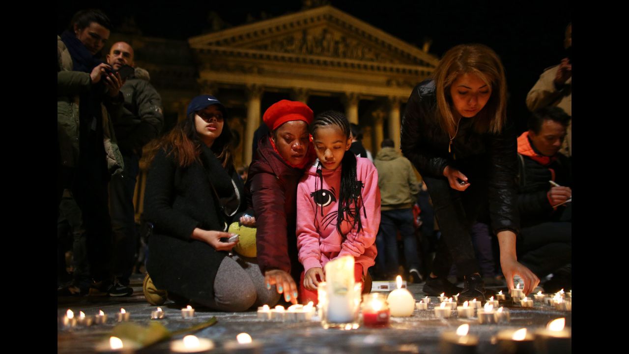 A young girl lights a candle at the Place de la Bourse in Brussels on Tuesday, March 22.