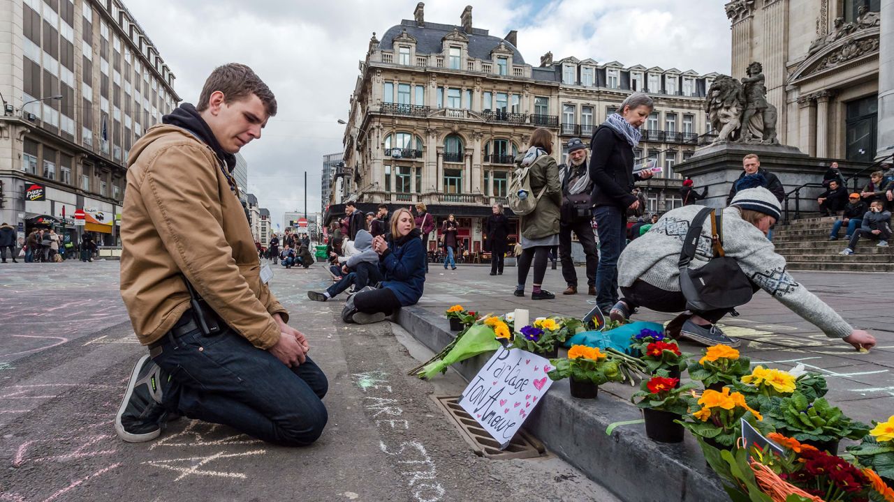 A man looks at flowers and messages outside the stock exchange in Brussels on March 22.