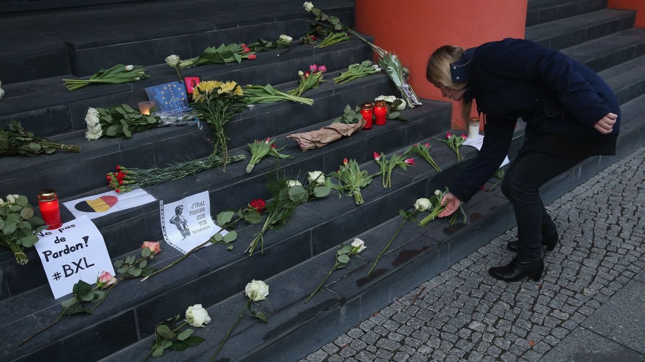 A woman lays flowers at the steps of the Belgian Embassy in Berlin on March 22.