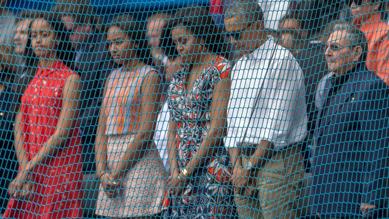 U.S. President Barack Obama and his family observe a moment of silence as they attend a baseball game in Havana, Cuba, with Cuban President Raul Castro, right, on March 22.
