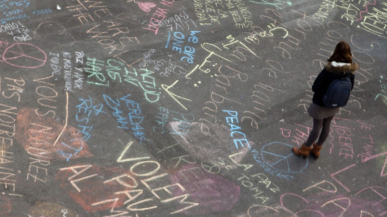 A woman reads messages written on the ground at Brussels' Place de la Bourse on March 22.