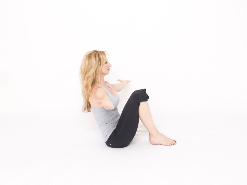 While seated on the floor, curl yourself into a ball with your feet on the floor. Keep your knees and feet together to engage adductors (groins) for hip and pelvic floor stability. Inhale as you reach your arms out to the sides, palms up, without letting your shoulders elevate. Exhale as you bring your arms together in front of you. Do three repetitions. Drop your knees out in a cobbler's or butterfly pose to release your groins and hips; if hip mobility is limited, additional hip-opening postures are recommended. Repeat for another set of three. 