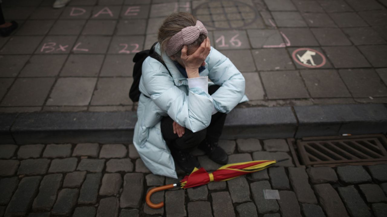 A woman in Brussels pauses after people observed a minute of silence at the Place de la Bourse on March 23.