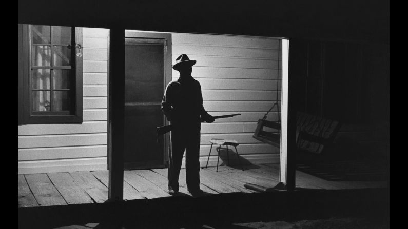 The Rev. Joe Carter guards his Louisiana house from the Ku Klux Klan after he registered to vote in 1964. "If they want a fight, we'll fight," Carter said. "If I have to die, I'd rather die for right. I value my life more since I became a registered voter. A man is not a first-class citizen, a number one citizen, unless he is a voter."