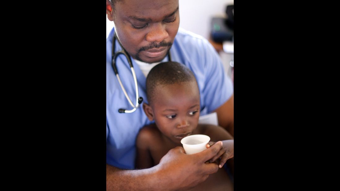 OneWorld Health volunteer Dr. Kojo Abbeqquaye assists a young child in Uganda.