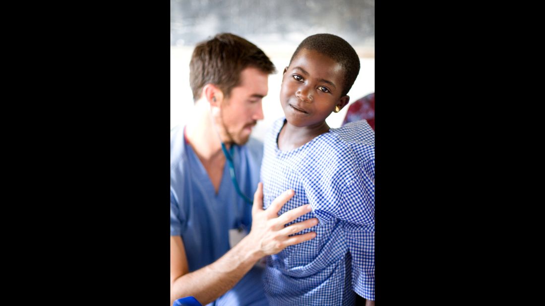 Dr. Cody Carpenter, a volunteer with OneWorld Health, checks on a patient during an outreach clinic in rural Uganda.