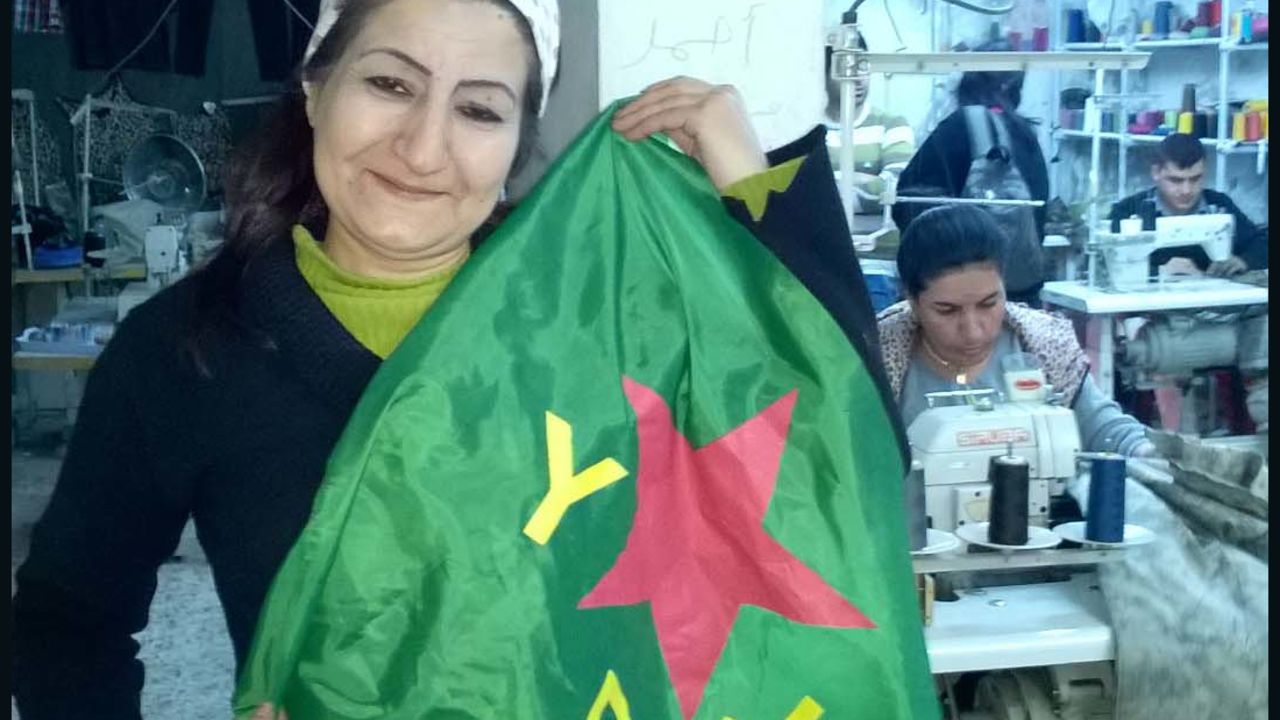 The YPJ flag belongs to the women's defence units and was 'modelled' by a worker in a sewing collective.
