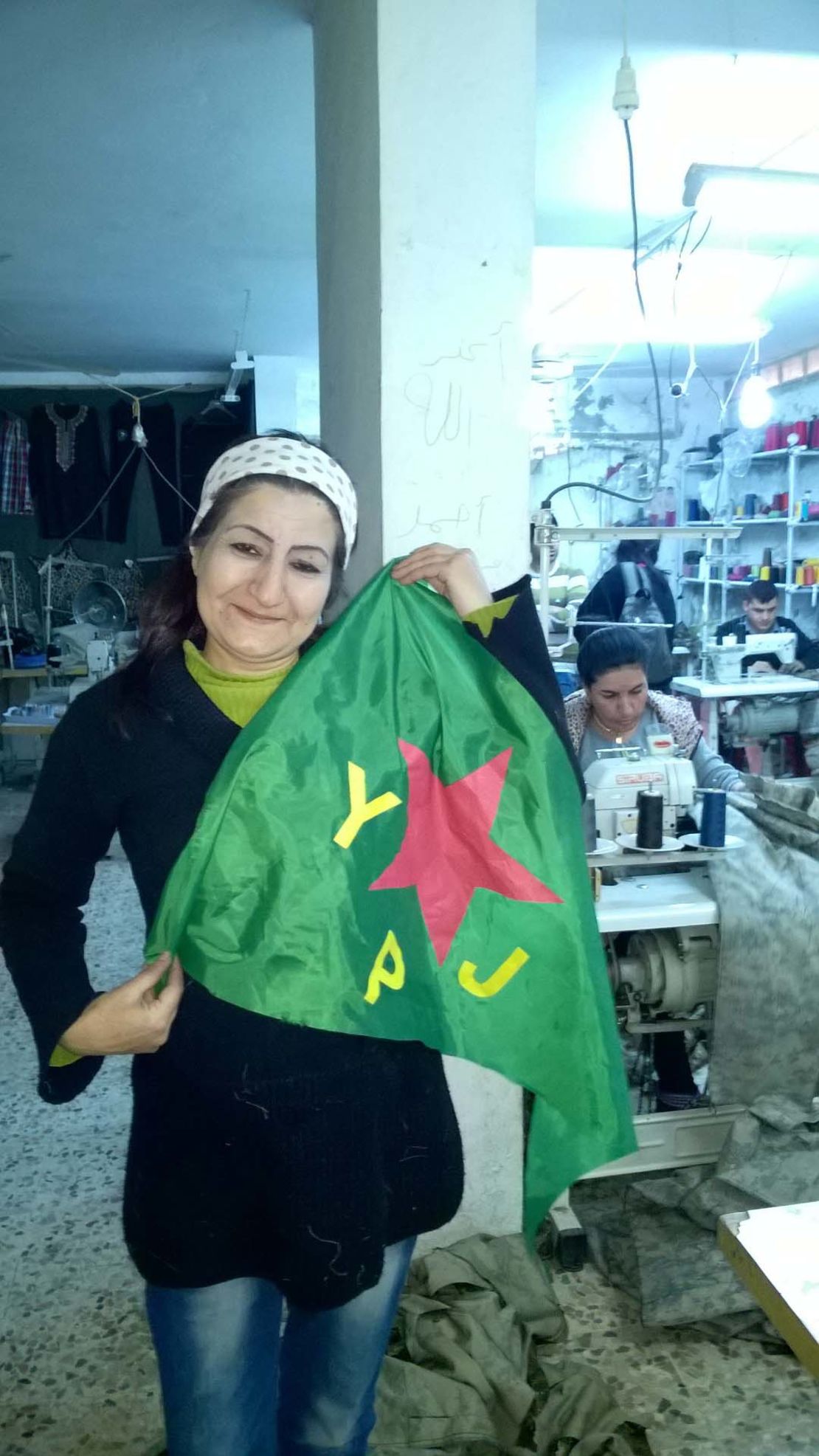 The YPJ flag belongs to the women's defence units and was 'modelled' by a worker in a sewing collective.