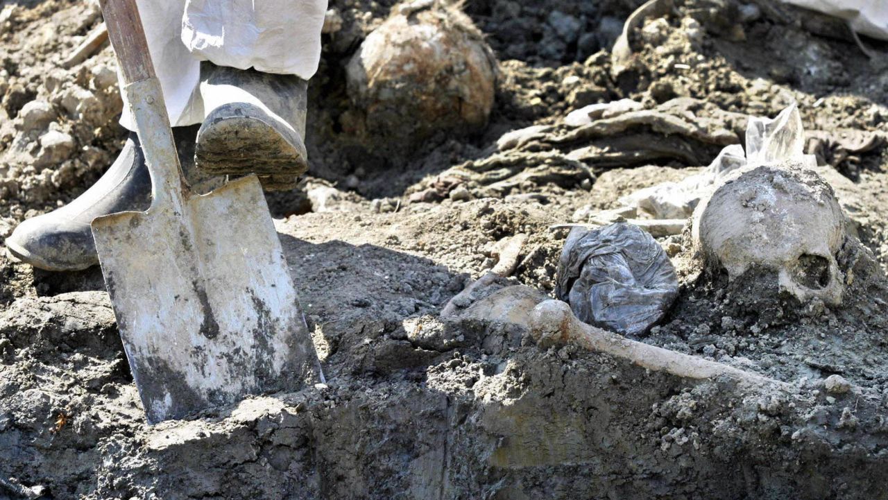 PRIJEDOR, BOSNIA AND HERCEGOVINA:  Forensic experts exhume the remains of 85 Muslim civilians from a mass grave in Kevljani, near Prijedor, some 100 km from Banja Luka 07 September 2004. The civlians are believed to have been inmates of a notorious Serb detention camp from the 1992-95 war, AFP PHOTO STRINGER  (Photo credit should read -/AFP/Getty Images)