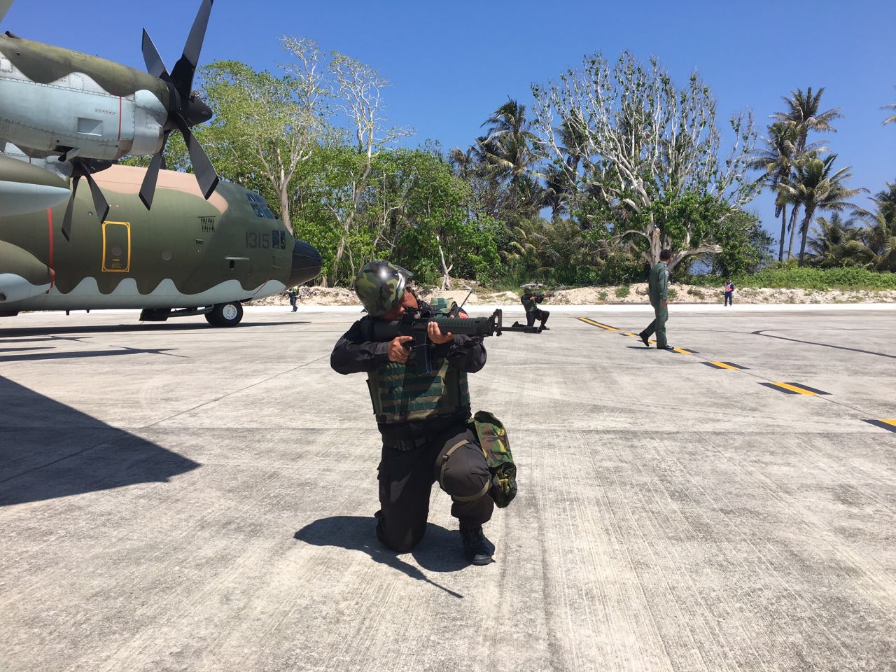 Uniformed Taiwan troops posed with rifles for journalists arriving on Taiping Island aboard a military C130 cargo plane March 23, 2016.   Outgoing Taiwan president Ma Ying-jeou says he wants to transform Taiping into "an island for peace and rescue operations." 