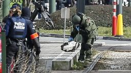 epa05230635 A Belgian bomb disposal expert in heavy protection gear (C) examines a suspicious object at the scene of an apparent operation against terror suspects near the Meizer round about in the Schaerbeek district of Brussels, Belgium, 25 March 2016. Media reported the sound of gunfire and explosions during the raid which is believed to be linked to the investigation into the 22 March Brussels terrorist attacks which caused the death of at least 31 people and injured hundreds of others and for which the so-call 'Islamic State' (IS) had claimed responsibility. According to Belgian RTBF broadcasting company one person was arrested in the operation.  EPA/JULIEN WARNAN