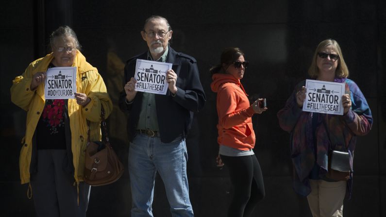 Demonstrators stand outside the office of U.S. Sen. Rob Portman, in Cincinnati, on Monday, March 21. A coalition of liberal groups staged rallies around the country on Monday targeting Republican senators who oppose confirmation hearings for President Barack Obama's Supreme Court nominee Merrick Garland.