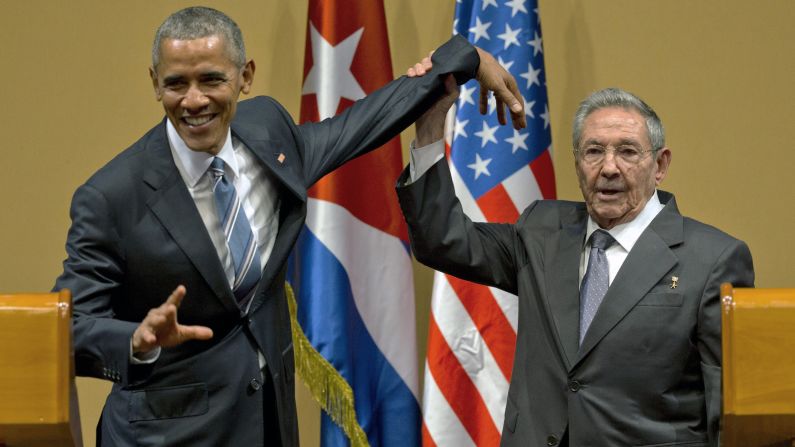 Cuban President Raul Castro tries to lift up the arm of U.S. President Barack Obama at the end of a joint news conference in Havana, Cuba, on Monday, March 21.