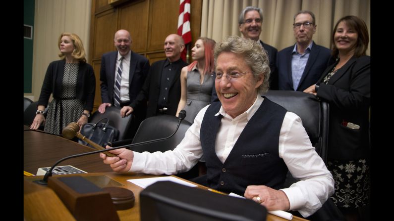 Roger Daltrey, lead singer of the English rock band "The Who" and co-founder of Teen Cancer America, jokingly poses with the gavel seated on the chairman's chair in a hearing room on Capitol Hill in Washington, Wednesday, March 23, at the conclusion of a "conversation on child cures" hosted by the House Energy and Commerce Committee. 