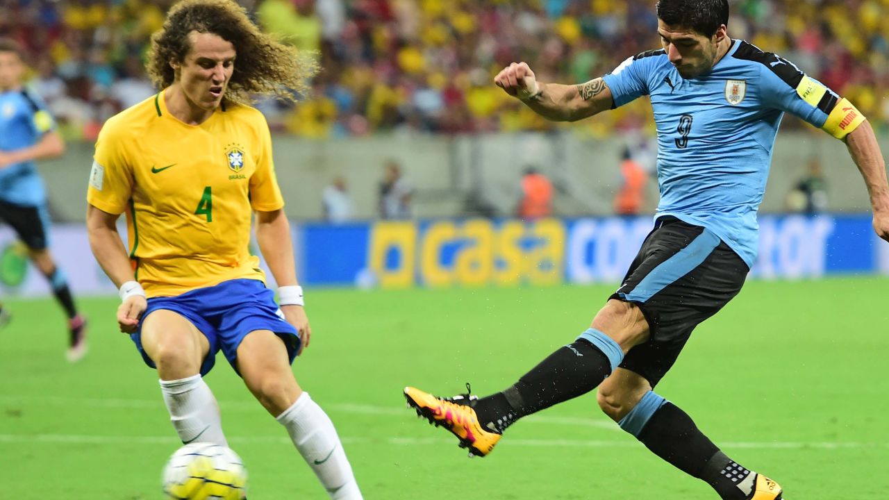 Suarez shoots to score his equalizer as Brazil's David Luiz looks on.
