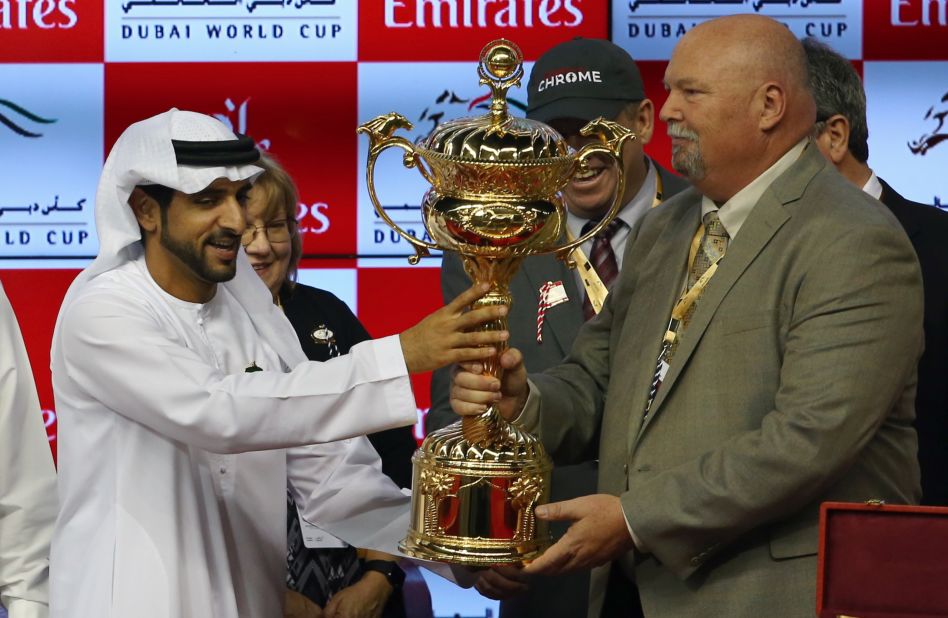 Sheikh Hamdan Bin Mohammad Bin Rashid al-Maktoum,  crown prince of Dubai, presents the owners of U.S. horse California Chrome with the Dubai World Cup trophy.