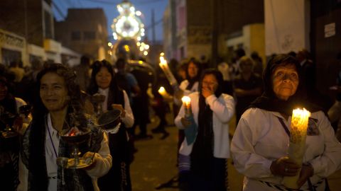 The faithful light candles during a Good Friday procession in Lima, Peru. 