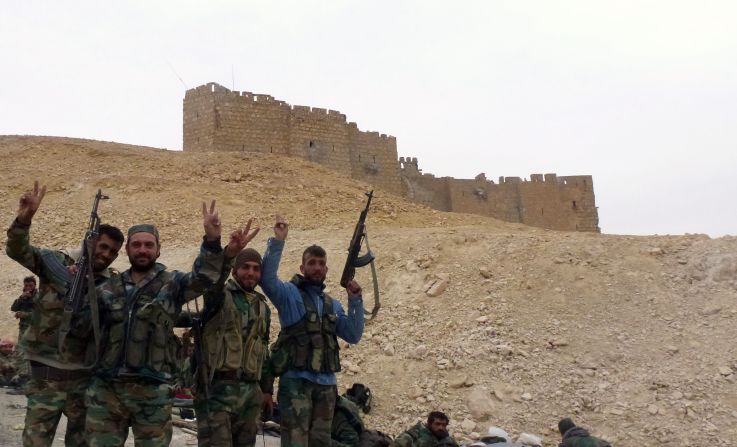 Syrian forces pose next to the Palmyra Castle on March 26.
