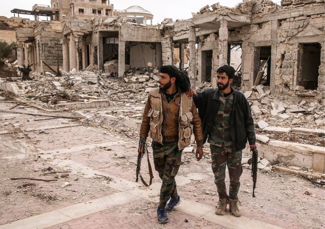 Syrian soldiers survey the damage to a villa belonging to the Qatari royal family on March 25. The villa near Palmyra served as an ISIS headquarters after being abandoned by its owner.