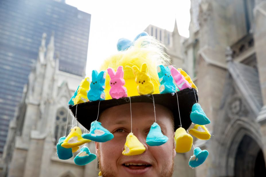 A man wears a bonnet featuring marshmallow bunnies and ducklings. 